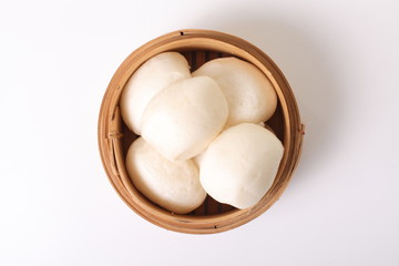 dim sum in bamboo steamer against a white background