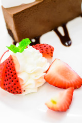 Fresh strawberry with whipped cream and chocolate cake.