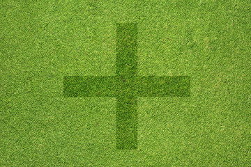 Plus icon on green grass texture and  background