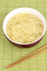 asian noodles in bowl on bamboo mat