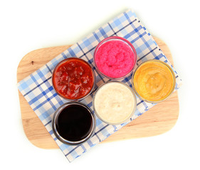 various sauces on chopping board isolated on white