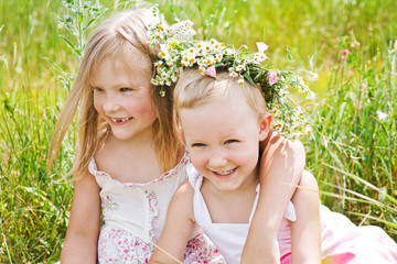 Little girls playing on a summer meadow