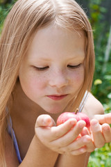 The little girl holding an apple in the hands