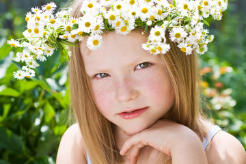 A pretty little girl in wreath of flowers