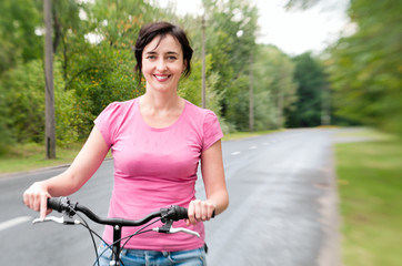 Fototapeta na wymiar Kobieta z rowerem na deszczowej drogi leśnej. Efekt Lensbaby