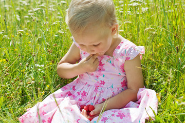 Little girl eating raspberries