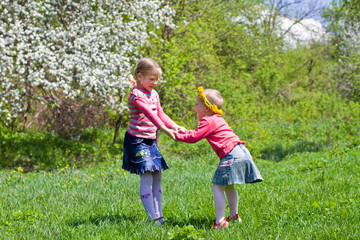 Little girls playing on a spring meadow