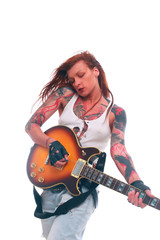 Attractive punk girl with tattoos playing electrical guitar