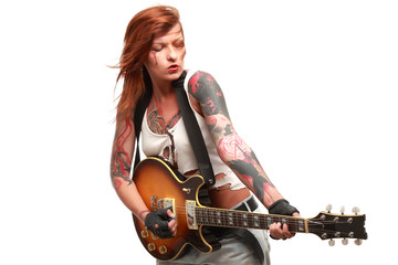 Attractive punk girl with tattoos playing electrical guitar
