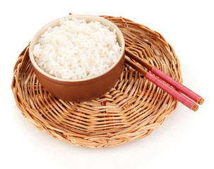 Bowl of rice and chopsticks on wicker mat isoalted on white