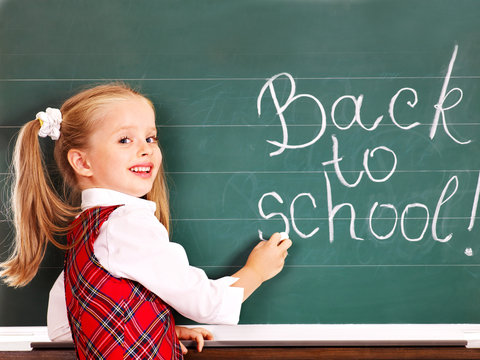 Child writting on blackboard.