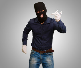 Man wearing robber mask and holding airplane miniature