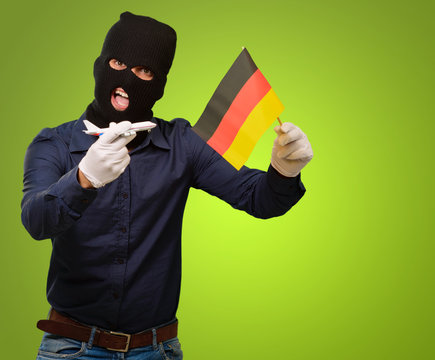 Man wearing a robber mask and holding airplane miniature and fla