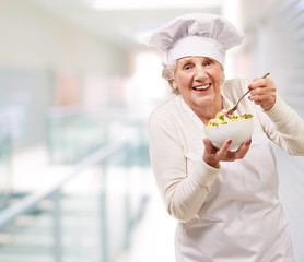 portrait of senior cook woman eating indoor