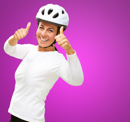 Woman wearing helmet showing thumb up