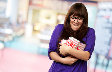 Portrait Of Young Woman Holding Popcorn Container