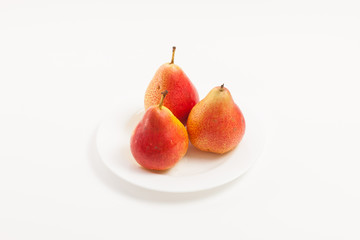Ripe yellow pear on white plate