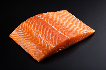 fresh salmon steak over black background