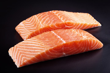 Piece of raw fresh salmon isolated on black background