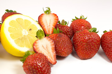 Lemons and strawberries on white