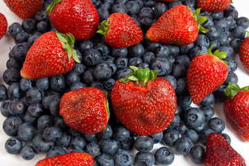 Blueberries and strawberries on white