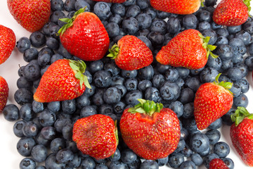 Blueberries and strawberries on white