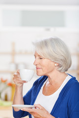 ältere frau genießt kaffee in der küche