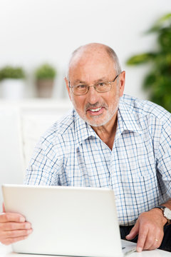 älterer mann mit laptop zu hause