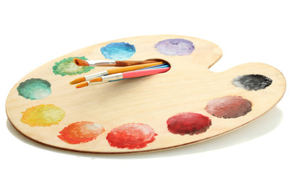 wooden art palette with paint and brushes isolated on white
