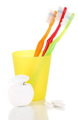 Toothbrushes, chewing gum and dental floss isolated on white