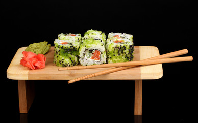 Tasty rolls served on wooden plate isolated on black