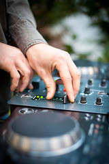 Young man working as dj with mixer. Shallow focus on hands.
