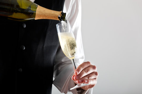 Waiter Pouring Champagne In A Flute