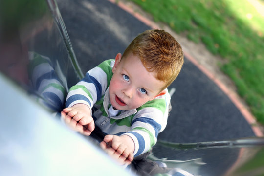 little boy slding down the slide at the park
