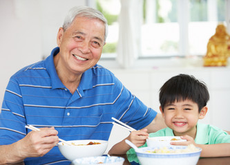 Portrait Of Chinese Granddad And Grandson Eating Meal Together