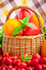 Wicker basket full of fresh tomatoes and cherry tomatoes
