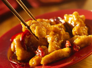 Chinese food - Eating general tso's chicken with chopsticks. - Powered by Adobe