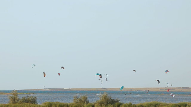 Colorful paragliders flying above the sea