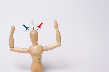 wood figure with a blue, white and red pin as to figure represen