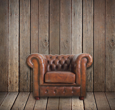 Classic brown leather armchair in wooden room.