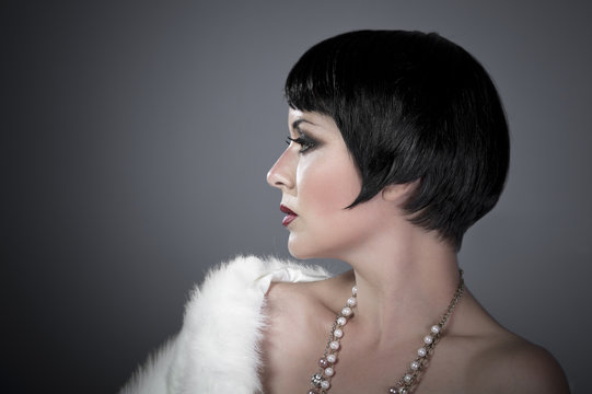 Gourgeos Female Brunette Flapper Profile Wearing Pearls And Fur