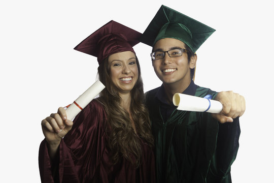 graduates in cap and gown with diplomas