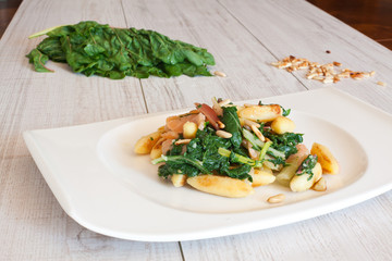 fresh salad with chard noodles and pine nuts on wooden table