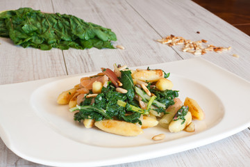 fresh salad with chard noodles and pine nuts on wooden table