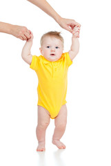 First steps of baby with help of mothers hands