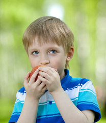 kid holding healthy food apple outdoor
