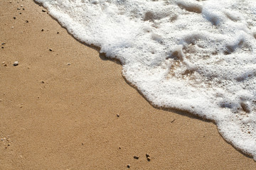 Welle überschwemmt den Strand