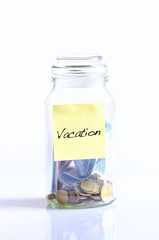 Glass jar with coins for vacation.