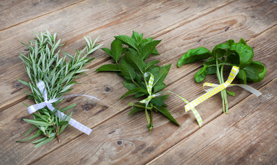 Rosemary, basil and pepermint plants on wooden table