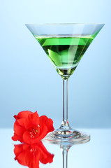 glass with cocktail and gladiolus bud